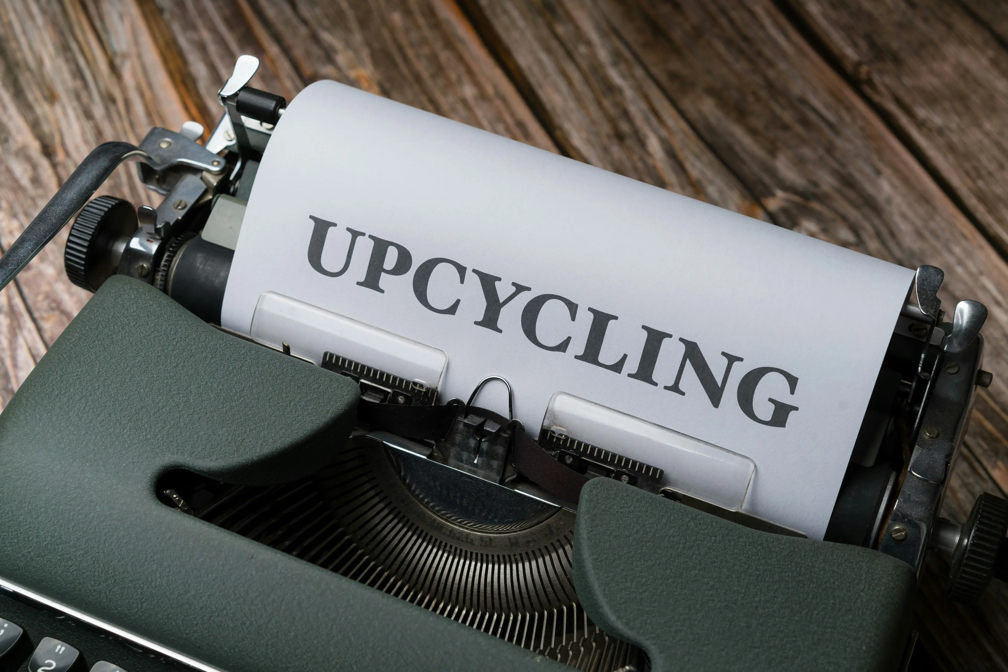 a close up of a typewriter with the word upcycling on it